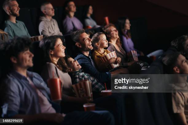 劇場で面白い映画を見ている陽気な家族。 - 映画のスクリーニング ストックフォトと画像