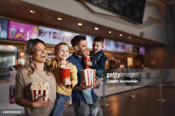 young happy family with popcorn and drinks in movie theatre. - film screening stockfoto's en -beelden