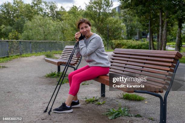woman sitting after nordic pole walking - nordic walking pole stock-fotos und bilder