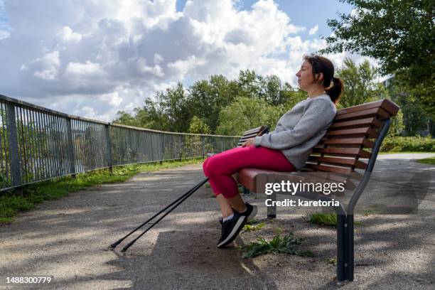 woman relaxing after nordic pole walking - nordic walking pole stock-fotos und bilder