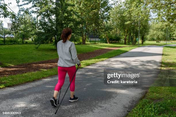 woman doing nordic pole walking - nordic walking pole stock-fotos und bilder