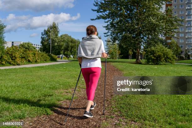 woman doing nordic pole walking - nordic walking pole stock-fotos und bilder