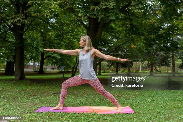 woman doing yoga poses in park - showus fitness stock pictures, royalty-free photos & images