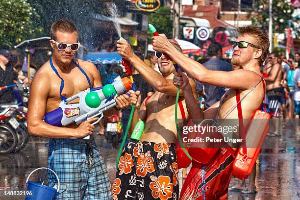 foreign tourists enjoying the fun at the songkran festival. - songkran man stock pictures, royalty-free photos & images
