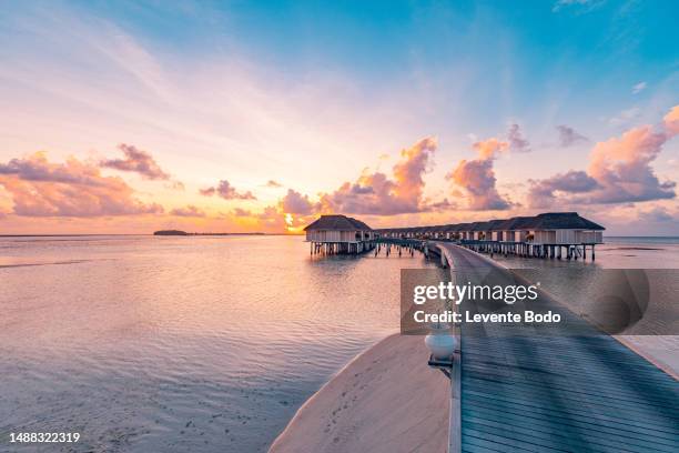 amazing beach landscape. beautiful maldives sunset seascape view. horizon colorful sea sky clouds, over water villa pier pathway. tranquil island lagoon, tourism travel background. exotic vacation - exoticism stock pictures, royalty-free photos & images