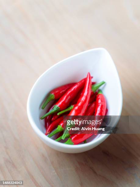 the red chili pepper is on the wooden kitchen counter. - jalapeno pepper ストックフォトと画像