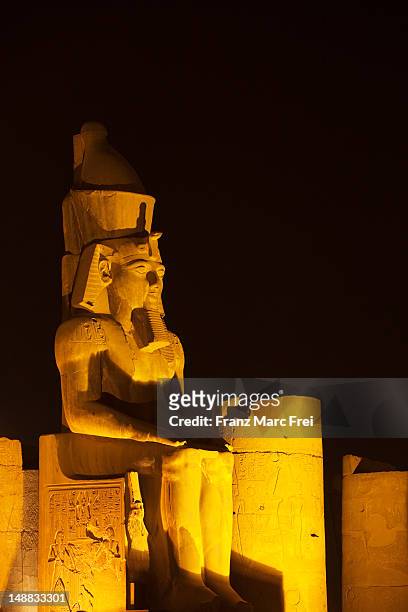 colossal statue of sitting ramesses ii. in the great courtyard in the temple of luxor, ancient thebes. - statue von pharao ramses ii stock-fotos und bilder