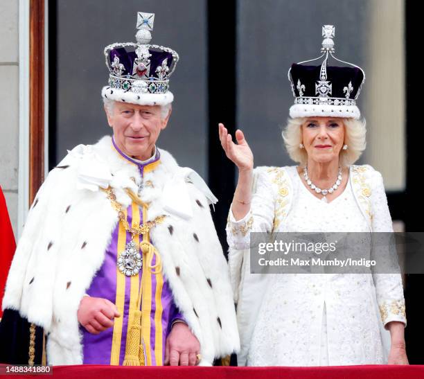 King Charles III and Queen Camilla watch an RAF flypast from the balcony of Buckingham Palace following their coronation at Westminster Abbey on May...