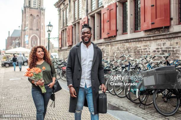 beautiful travellers biking in delft on a sunny day - delft stock pictures, royalty-free photos & images