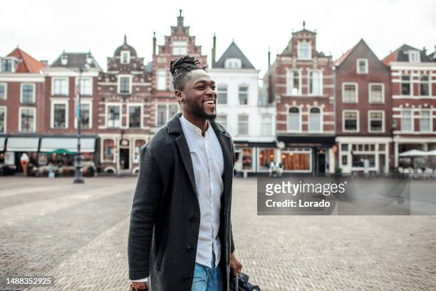 portrait of a handsome black man in a dutch street - three quarter length stock pictures, royalty-free photos & images
