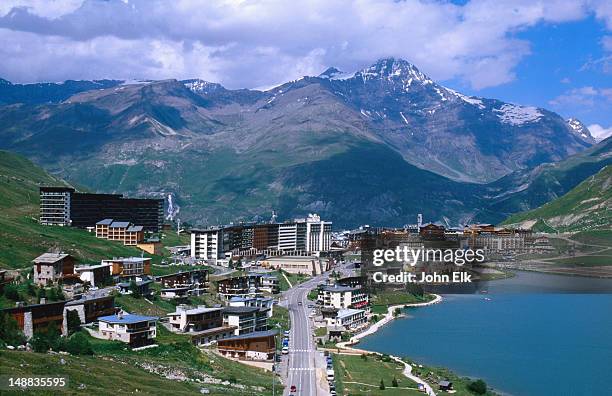 overhead of town and lake with mountain in background. - tignes stock pictures, royalty-free photos & images