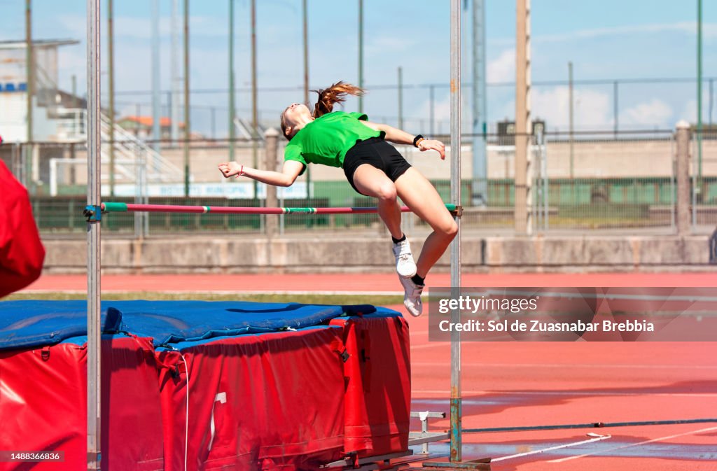 Teenage girl flying in a high jump