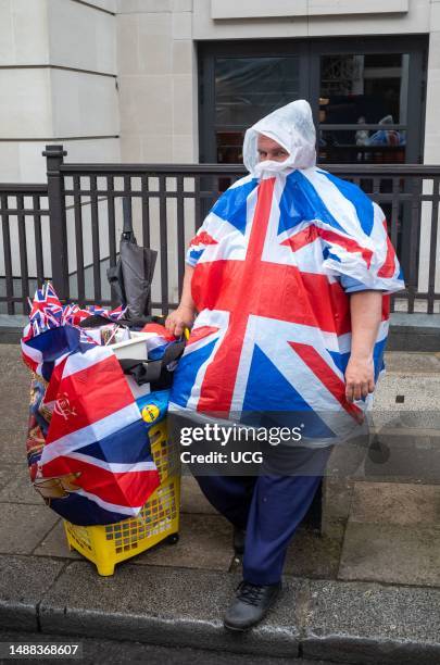 In central London, on the day of King Charles III's coronation, an large unlicensed street vendor was doing a brisk business selling raincoats...