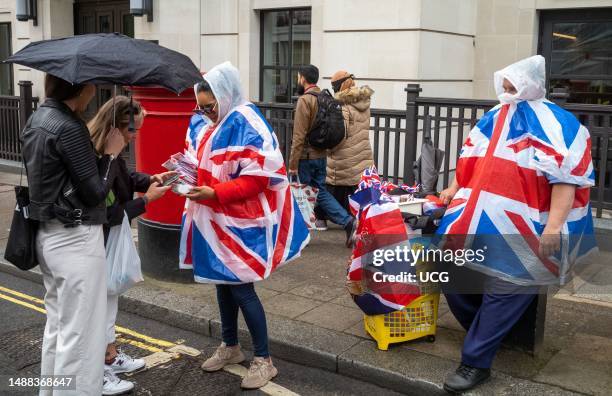 In central London, on the day of King Charles III's coronation, street vendors were doing a brisk business selling raincoats adorned with the Union...