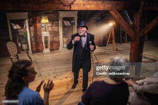 senior man actor performing on stage for a an audience - amateur theater stock pictures, royalty-free photos & images