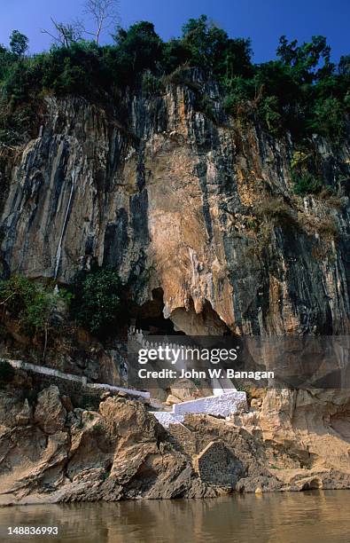a series of white-washed steps leads into the pak ou caves at the mouth of the nam ou. the caves have been formed inside of a limestone cliff - pak ou caves stock pictures, royalty-free photos & images