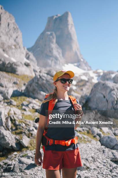 backpacker explores rugged mountain terrain - calções cor de laranja imagens e fotografias de stock