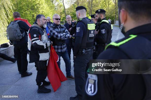 Police confront members of a Russian-speaking motorcycle club who had unfurled a Soviet flag at the Soviet World War II memorial at Treptower Park on...