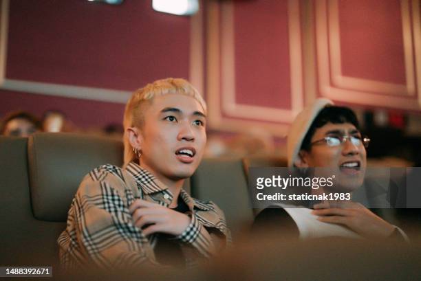 happy gay couple watching movie at cinema. - asian cinema stock pictures, royalty-free photos & images
