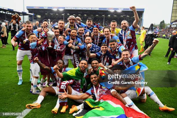 Players of Burnley celebrate with the Sky Bet Championship trophy as they celebrate promotion to the Premier League after defeating Cardiff City...