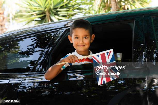 boy in car is holding british flag - kid national flag stock pictures, royalty-free photos & images