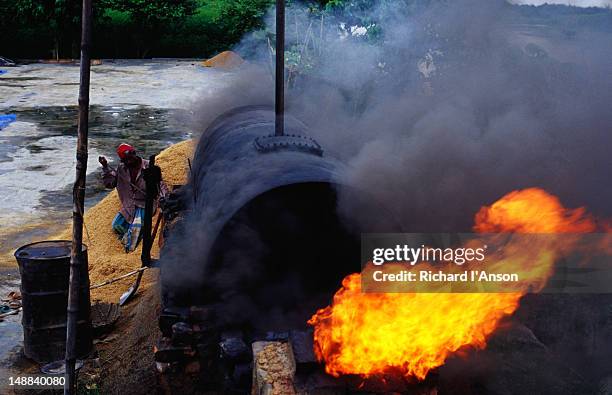 labourer burning rice husks at rice mill. - rice milling stock pictures, royalty-free photos & images