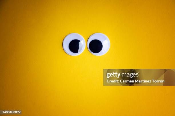 googly eyes on orange background. - comic augen stock-fotos und bilder
