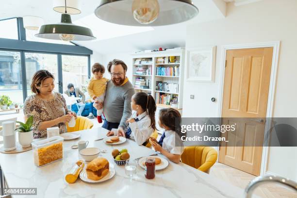 famiglia asiatica britannica a casa nel regno unito, padre e madre che aiutano i bambini a prepararsi per la scuola - famiglia a casa foto e immagini stock