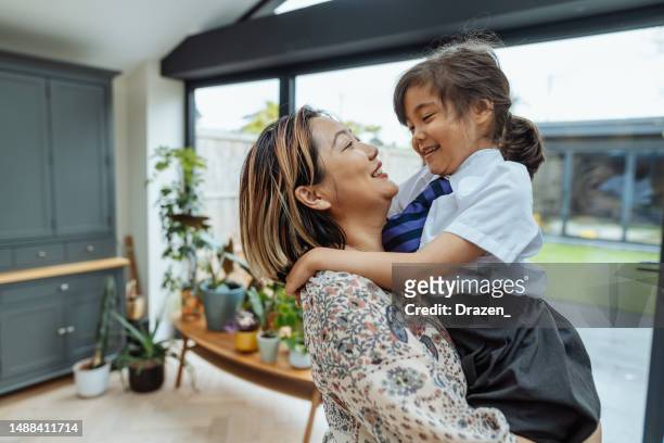 asian mother preparing girl to go to school - first day school hug stock pictures, royalty-free photos & images