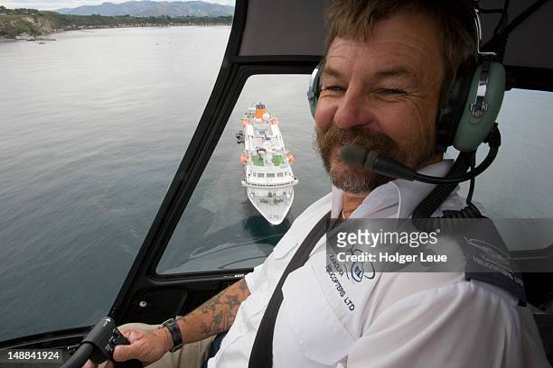 helicopter pilot with cruiseship ms bremen below. - inside helicopter stock pictures, royalty-free photos & images