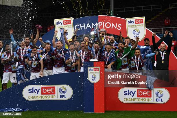 Jack Cork and Josh Brownhill of Burnley lift the Sky Bet Championship trophy with teammates after victory against Cardiff City during the Sky Bet...