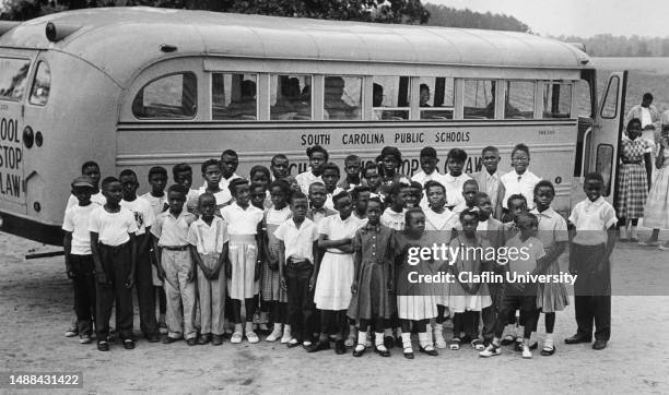 Group of school children posing in front of a school bus in Calhoun County in South Carolina in the 1950s.