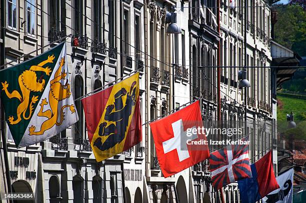 swiss flags flying from row of old city buildings. - swiss flag bildbanksfoton och bilder