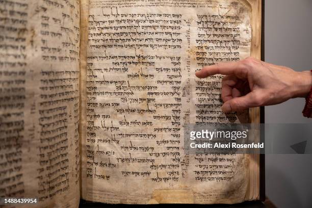 Sharon Mintz, Sotheby's senior Judaica specialist for books and manuscripts, points to specific areas of the Codex Sassoon during a press preview at...