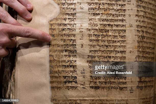 Sharon Mintz, Sotheby's senior Judaica specialist for books and manuscripts, points to the 'cheya sara passage of the Codex Sassoon during a press...