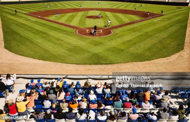 wide shot rear view crowd cheering during professional baseball game - baseball game stadium stock pictures, royalty-free photos & images