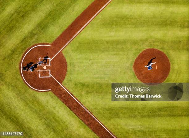 wide shot pitcher throwing to batter during professional baseball game - balle de baseball photos et images de collection
