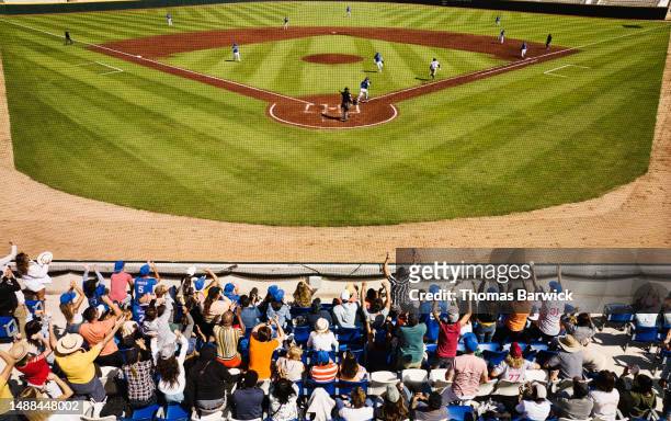 wide shot rear view crowd cheering during professional baseball game - baseball stadium stock pictures, royalty-free photos & images
