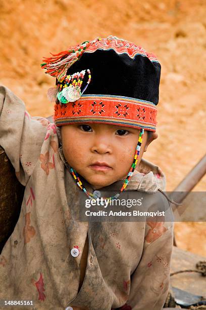 portrait of young hmong boy with traditional cap along route 34 between bao lac and cao bang. - bao lac stock pictures, royalty-free photos & images