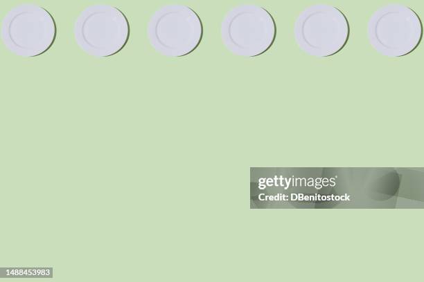 pattern of empty white plates, on top, on light green background. restaurant, food, catering, cooking, service, chef and haute cuisine concept. - tellerlift stock-fotos und bilder