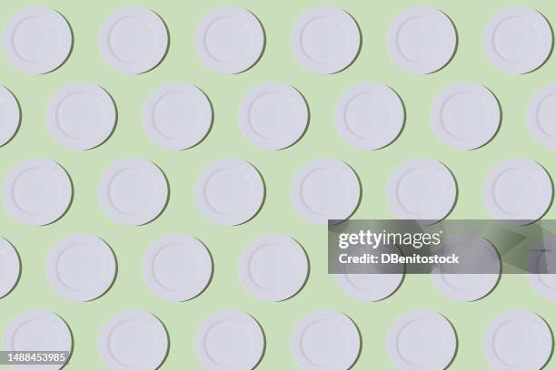 pattern of empty white plates on light green background. restaurant, food, catering, cooking, service, chef and haute cuisine concept. - tellerlift stock-fotos und bilder