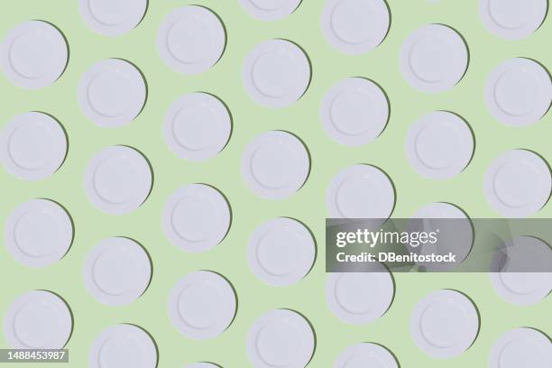pattern of empty white plates on light green background. restaurant, food, catering, cooking, service, chef and haute cuisine concept. - tellerlift stock-fotos und bilder
