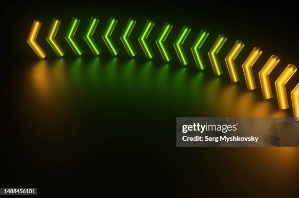 an arrow made of glass tubes with a neon glow inside of green and yellow. - neon arrow stock pictures, royalty-free photos & images