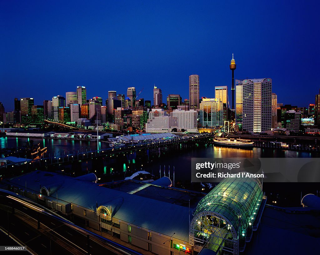 Darling Harbour at dusk with city buildings in background.