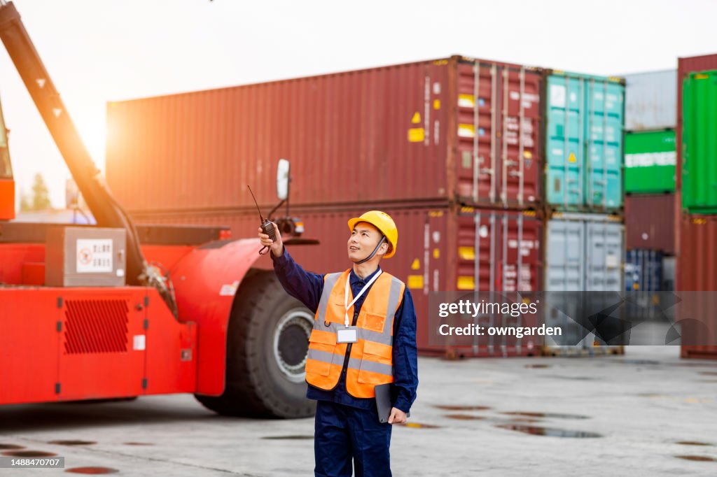 Container Worker Container Worker In Safety Suit Talking On Walkies Talkie At Cargo ...