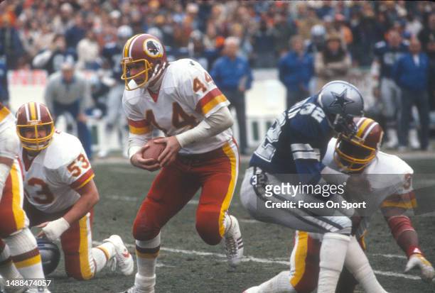 John Riggins of the Washington Redskins runs the ball against the Dallas Cowboys during an NFL NFC Championship game on January 22, 1983 at RFK...