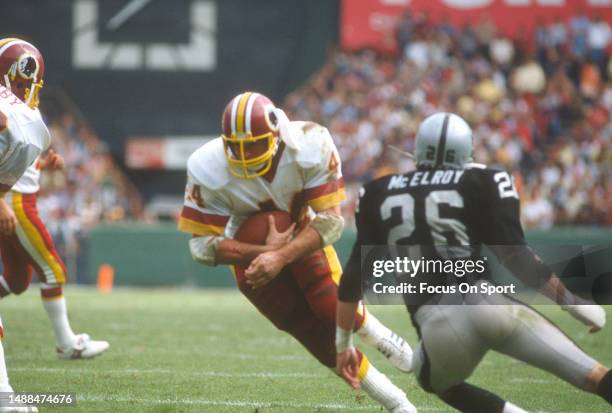 John Riggins of the Washington Redskins runs the ball during an NFL game against the Los Angeles Raiders on October 2, 1983 at RFK Stadium in...