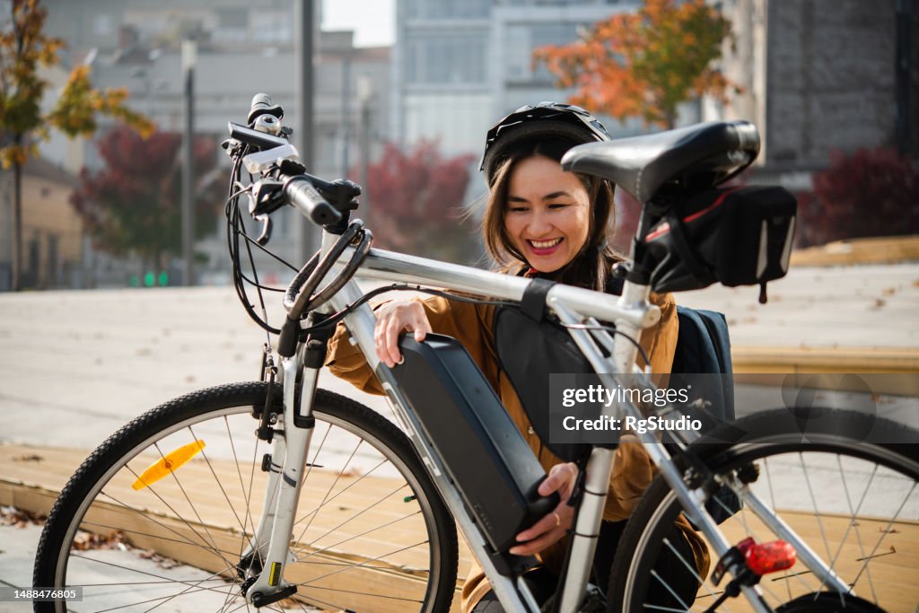 Asian businesswoman preparing her e-bike to go to work on it