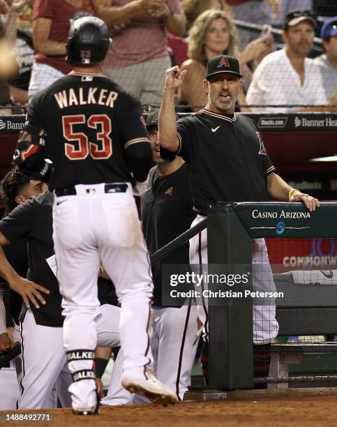 Manager Torey Lovullo of the Arizona Diamondbacks high fives Christian Walker after Walker hit a solo home run against the Miami Marlins during the...