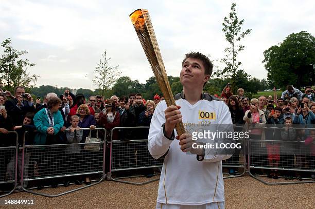 In this handout image provided by LOCOG, Torchbearer 001 Christopher Bury holds the Olympic Flame at Mote Park in Maidstone at the beginning of Day...